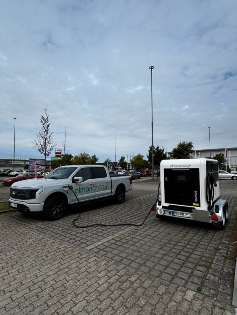 Mobiler Schnellladespeicher Almon Energy MX-210 lädt einen elektrischen Ford F-150 Lightning auf einem Parkplatz